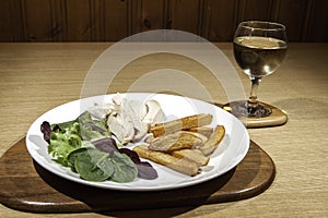 Healthy low calorie chicken meal with salad and wine